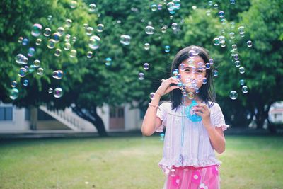 Full length of girl with bubbles in park
