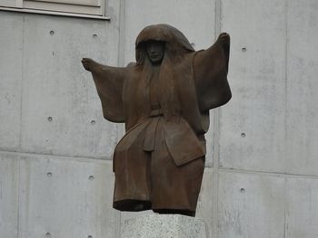 Low angle view of statue against wall against building