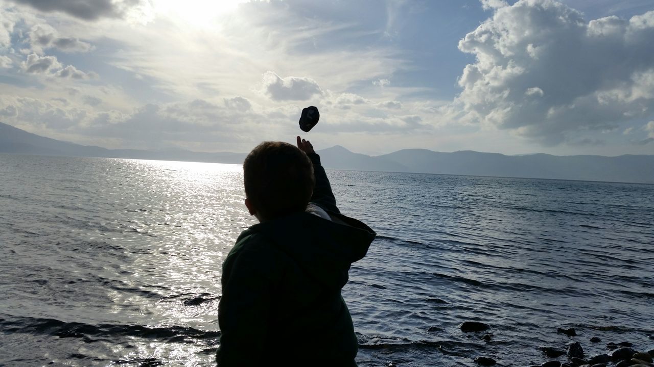 rear view, sea, water, standing, sky, lifestyles, leisure activity, waist up, silhouette, three quarter length, horizon over water, tranquility, tranquil scene, beauty in nature, scenics, looking at view, men, person