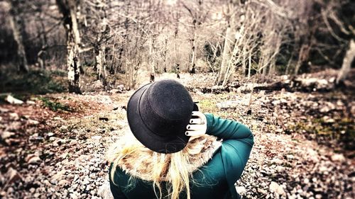 Close-up of woman hand by tree in forest