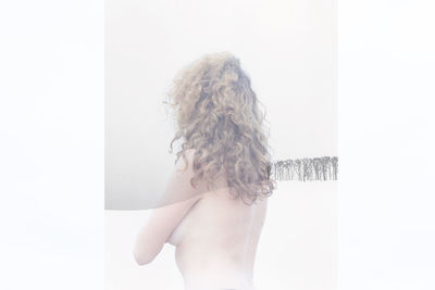 Close-up of young woman standing against white background