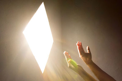 Close-up of praying hand holding illuminated light