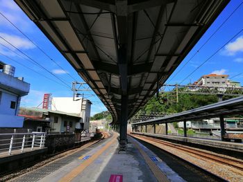 Railroad tracks in city against sky
