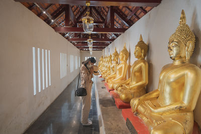 Asian female tourists worshiping at wat phra sri rattana mahathat, thailand.