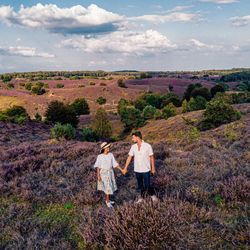 Couple standing on landscape against sky