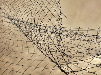 Low angle view of chainlink fence against sky