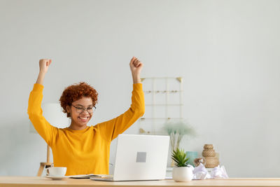 Rear view of man with arms raised against white background