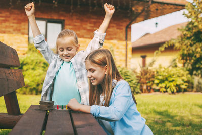 Girl and woman with arms raised