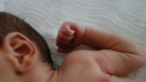 High angle close-up of baby boy lying on bed at home