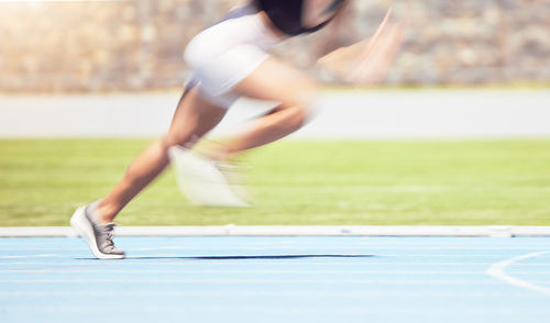 Full length of woman exercising on field