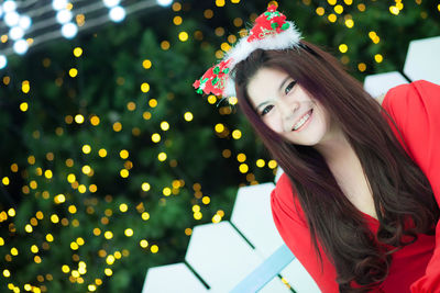 Portrait of smiling woman against christmas decoration