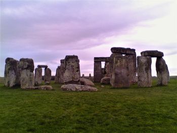 Old ruins in field against cloudy sky