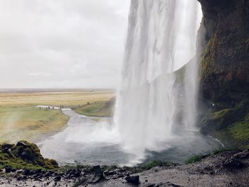 Scenic view of waterfall against sky