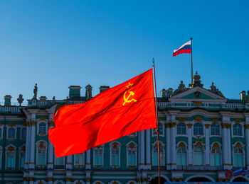 Flag against buildings in city against clear blue sky