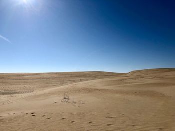 Scenic view of desert against clear blue sky