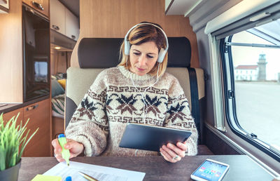 Young woman using mobile phone while sitting in bus