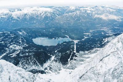 Aerial view of snowcapped mountains by sea