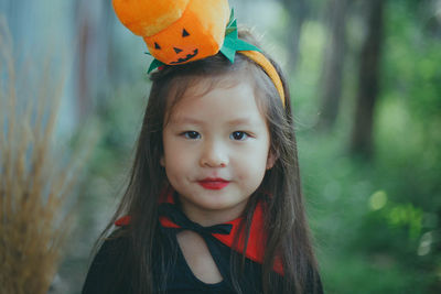 Portrait of girl wearing witch costume while standing against trees