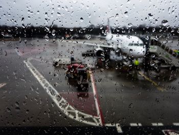 Cars on road seen through wet window during rainy season