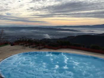 Scenic view of swimming pool against sky during sunset