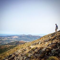 Man standing on mountain against clear sky