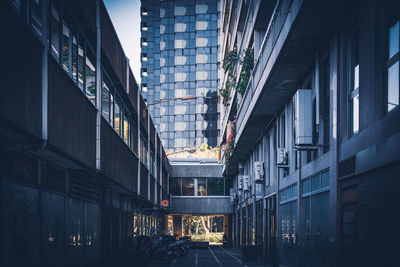 Street amidst buildings in city at dusk