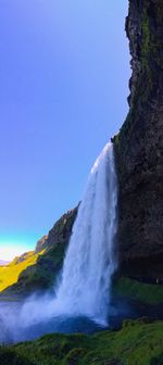 Scenic view of waterfall against clear sky