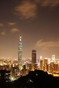 Illuminated cityscape against sky at night