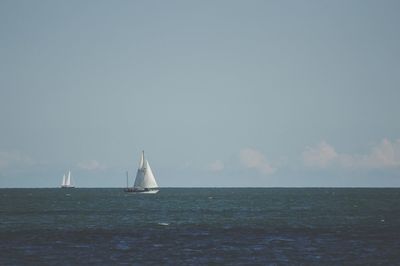 Sailboat sailing on sea against sky