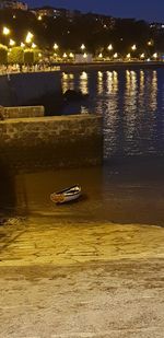 Sailboats moored on sea at night