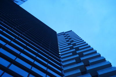 Low angle view of skyscraper against clear blue sky