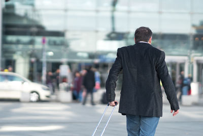 Businessman with luggage standing in city