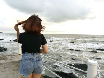 Rear view of woman standing on beach