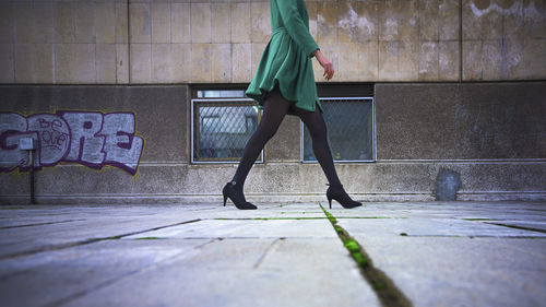 Low section of woman walking on footpath