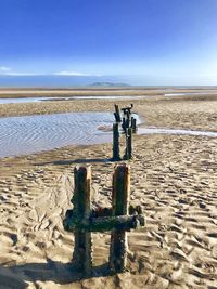 Steel posts on beach against clear sky