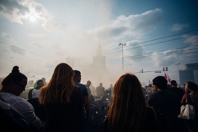 Rear view of people walking in front of buildings