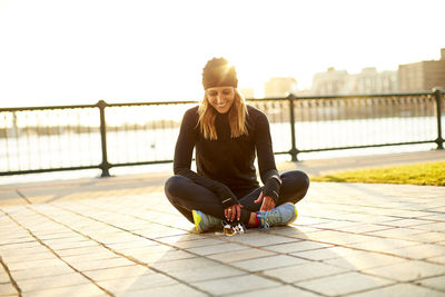 A happy backlit portrait of a female runner at rest.