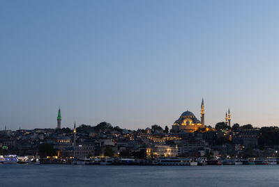 Buildings in city against clear sky highlighting sulemaniye mosque
