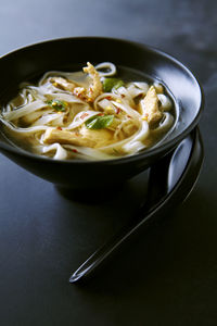 Chicken noodle soup in bowl with spoon