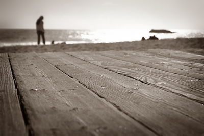 Close-up of man standing at beach against sky