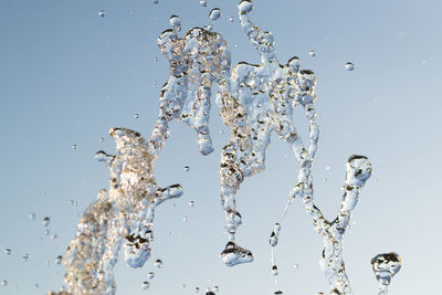 Low angle view of water splashing against sky