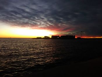 Scenic view of sea against dramatic sky during sunset