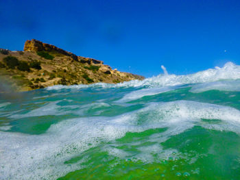 Scenic view of sea against clear blue sky
