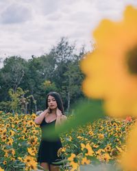 Woman standing on field with yellow flowers