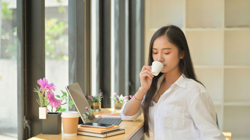 Beautiful woman drinking coffee cup on table