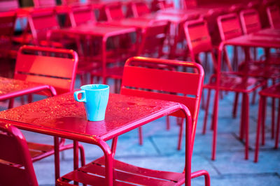 Blue coffee cup on wet metallic table at sidewalk cafe