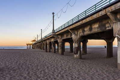 Bridge over sea against clear sky during sunset