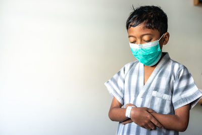 Full length of boy standing against white background