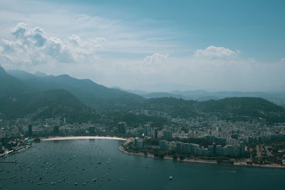 High angle view of city by sea against sky