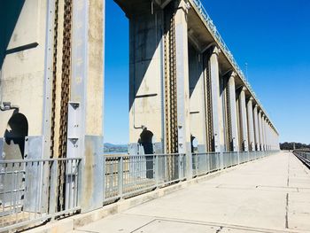 View of birds perching on bridge against clear sky